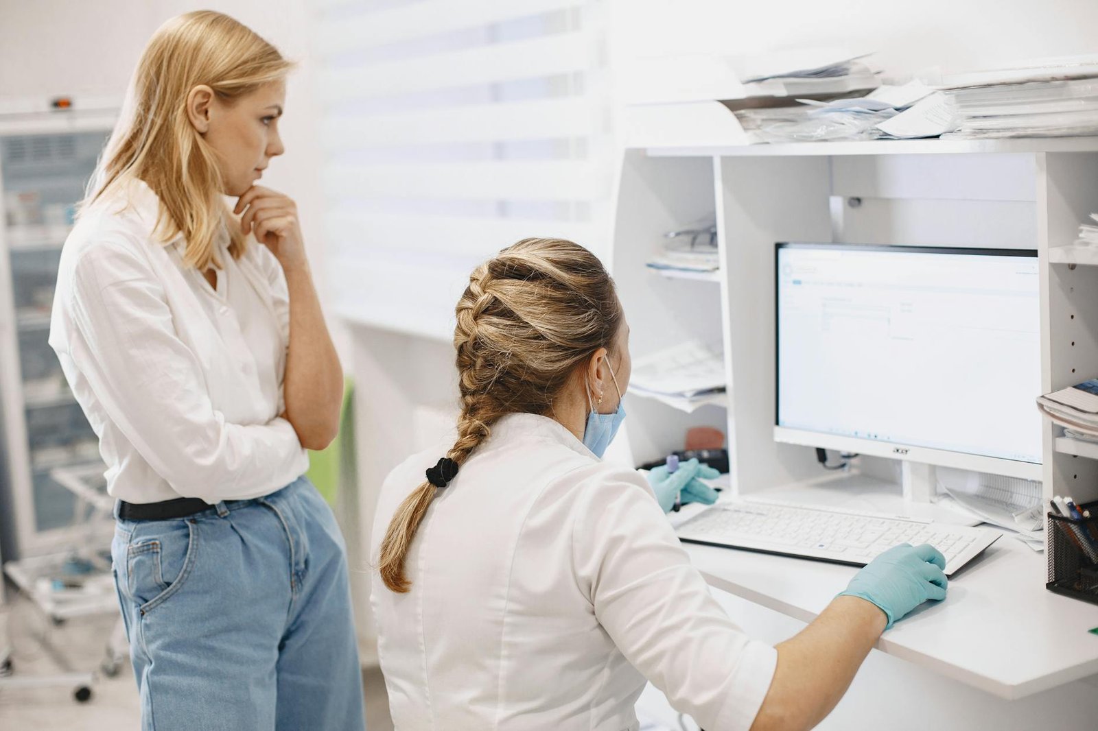 Two female healthcare workers collaborate in a clinical setting