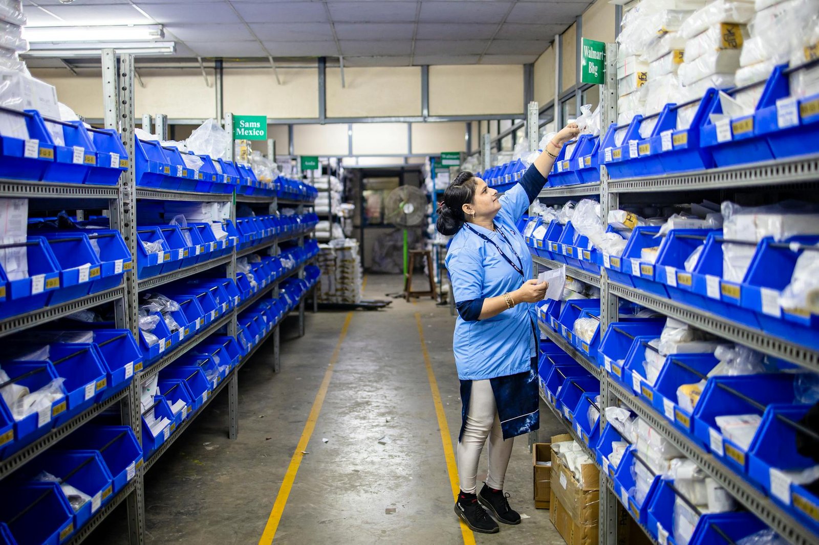 Woman in uniform organizing inventory in a warehouse