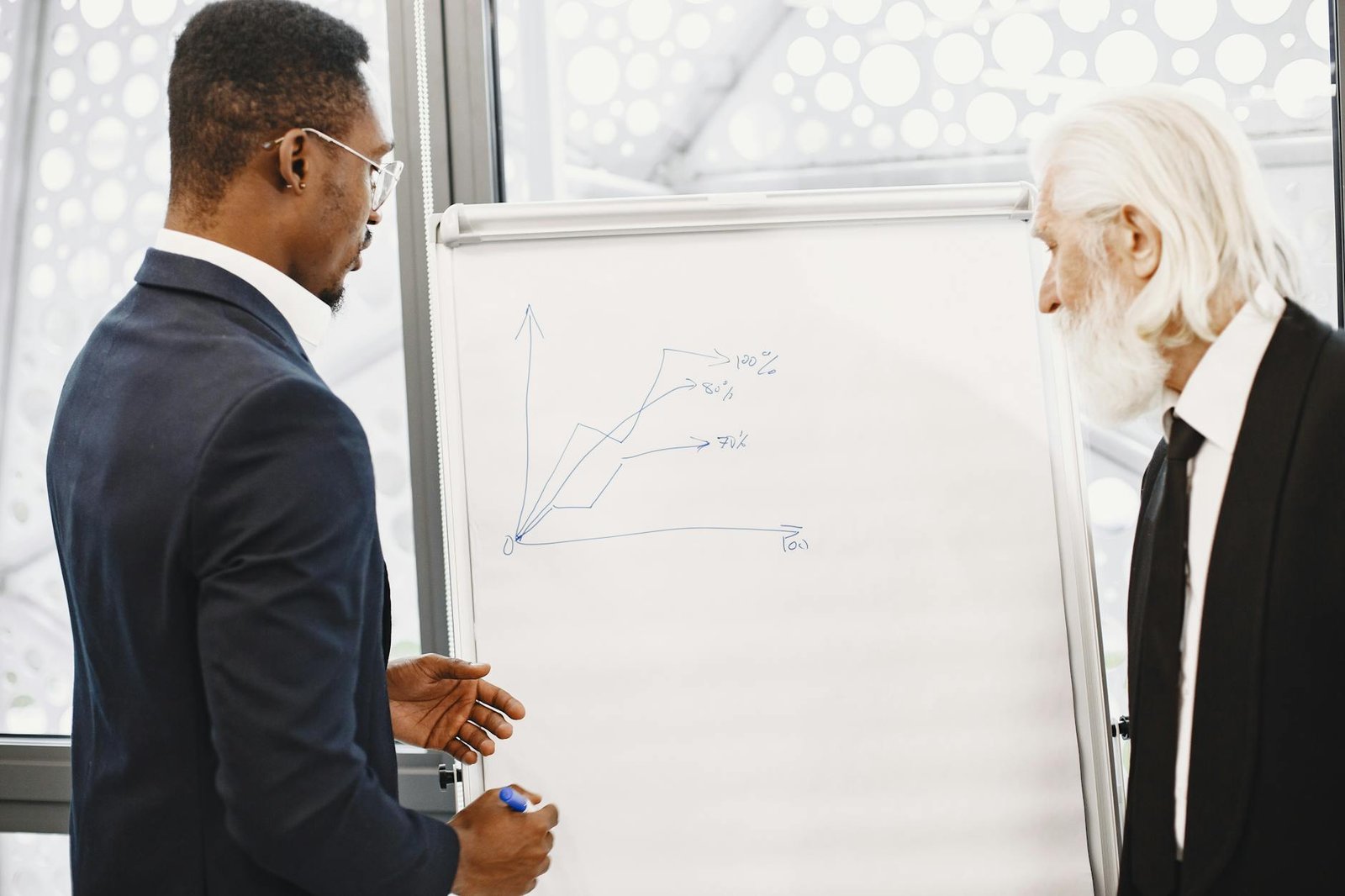 Two businessmen discussing financial charts at an office meeting.