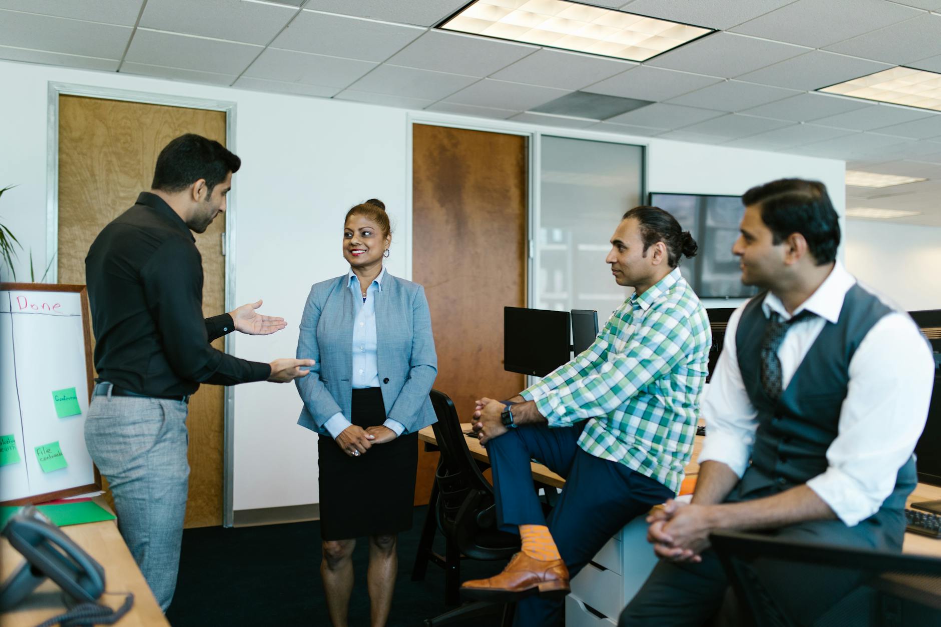 A diverse group of colleagues engaged in a collaborative meeting in a modern office setting.