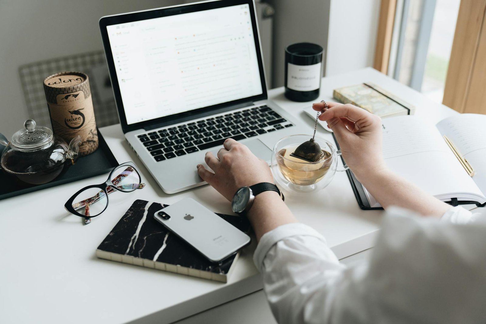 A cozy home office scene with a laptop, tea, and workspace essentials.