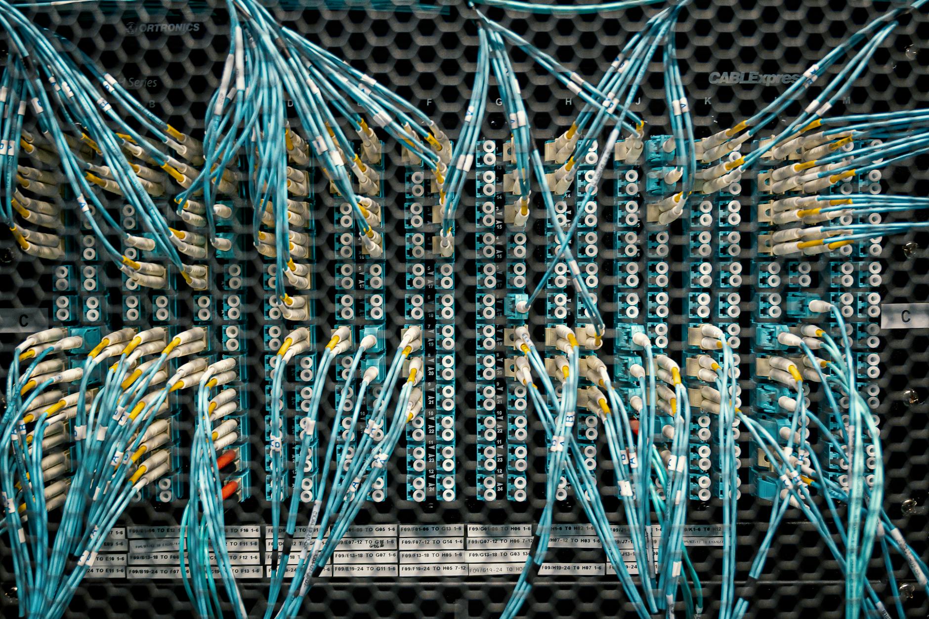 Overhead view of similar bright cables with plastic connectors in fiber optical switch