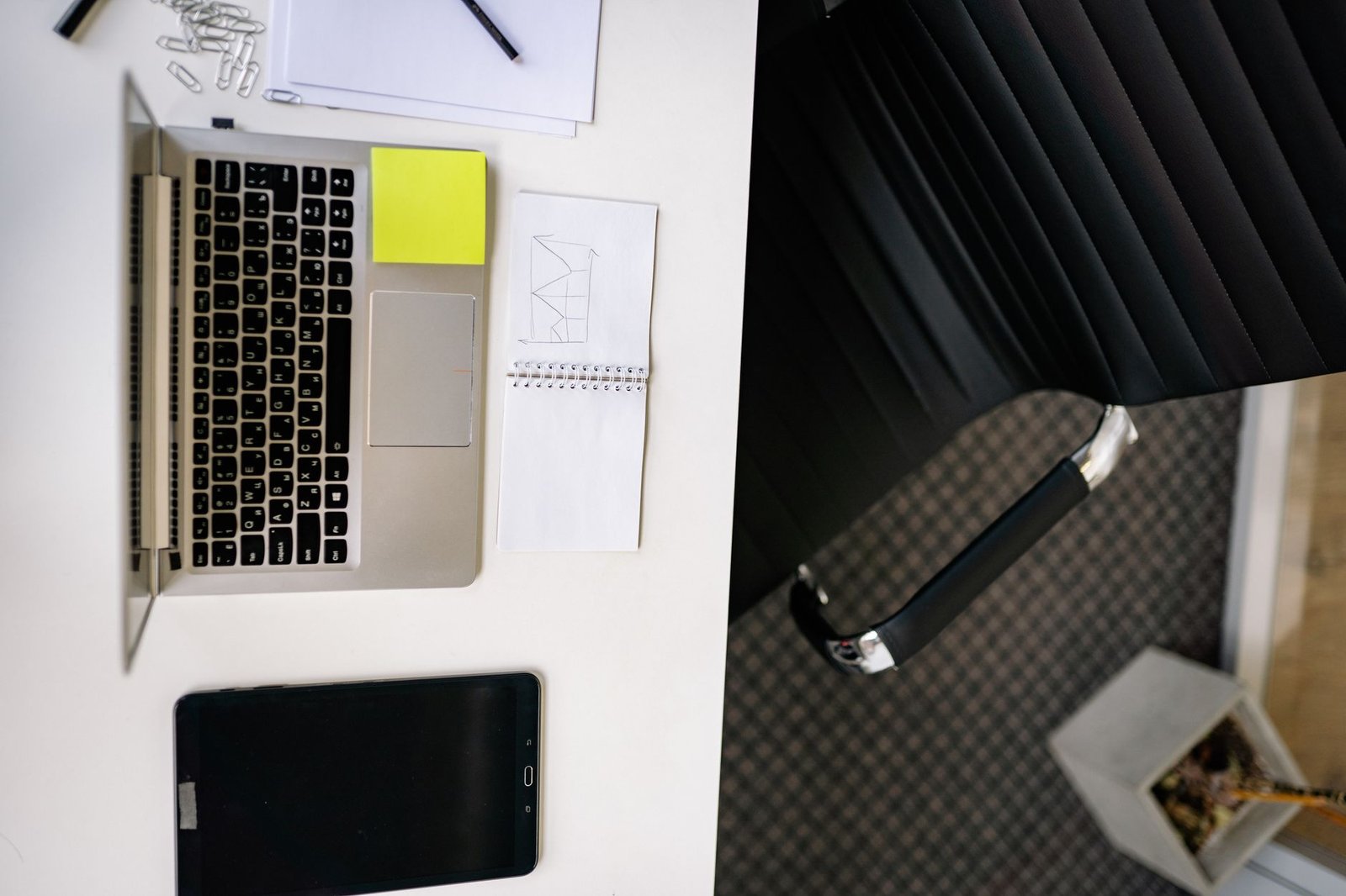 Electronic signature being applied on a tablet with a laptop in the background