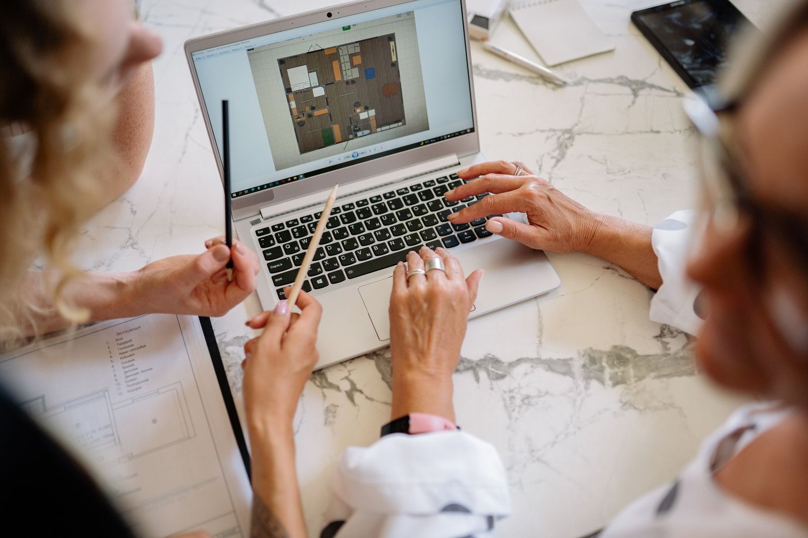 Team discusses interior layout on laptop in modern office setting.