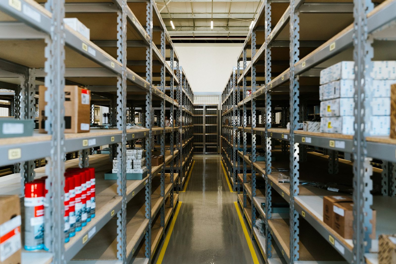 Wide view of an organized industrial warehouse with metal shelving and stored merchandise.