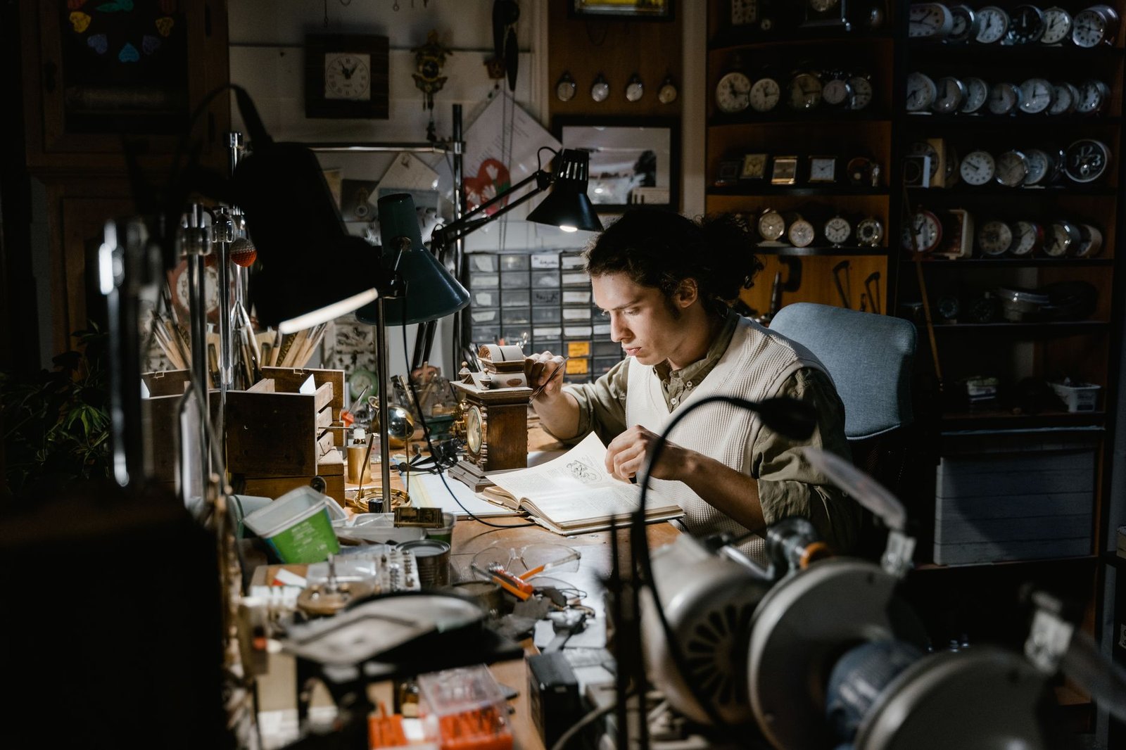 A dedicated craftsman meticulously works on a timepiece in a clock-filled workshop, highlighting precision and concentration.